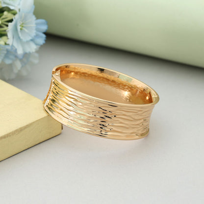 Goldfarbenes, aufklappbares, anlaufgeschütztes Armband im eleganten Party-Schmuckstil