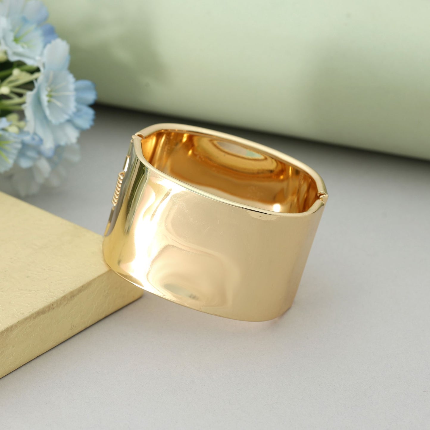 Goldfarbenes, aufklappbares, anlaufgeschütztes Armband im modernen Designer-Schmuck-Look