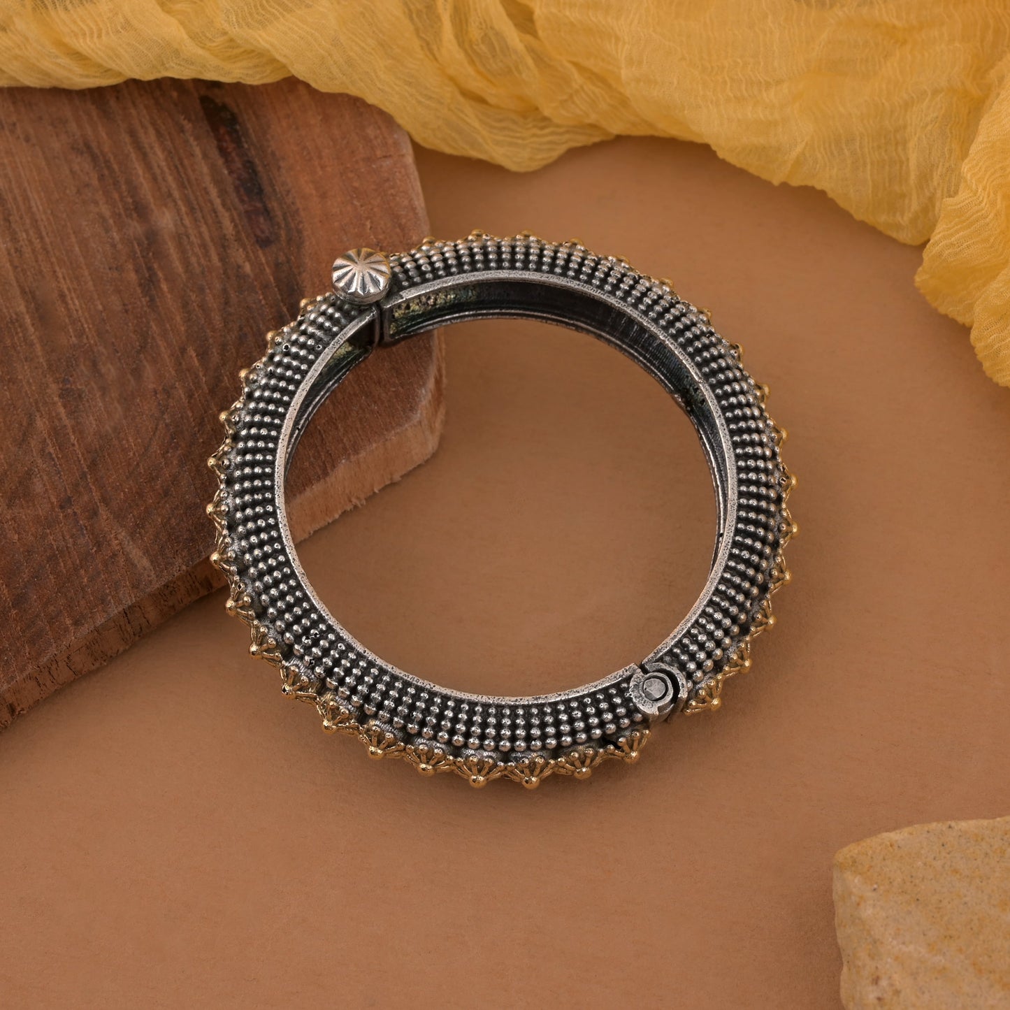 Elegantes, zweifarbiges, oxidiertes Armband zum Öffnen in Gold und Silber mit ethnischem Anhänger