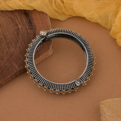 Elegantes, zweifarbiges, oxidiertes Armband zum Öffnen in Gold und Silber mit ethnischem Anhänger