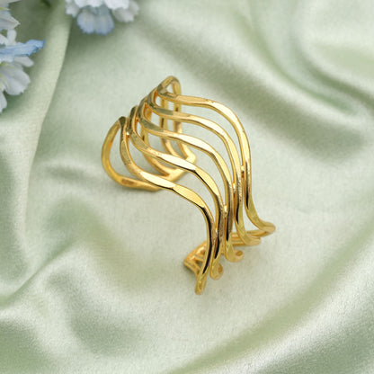 Goldfarbenes Armband, kreiert mit kunstvollen Details, um festliche Looks mit strahlendem Glanz zu unterstreichen